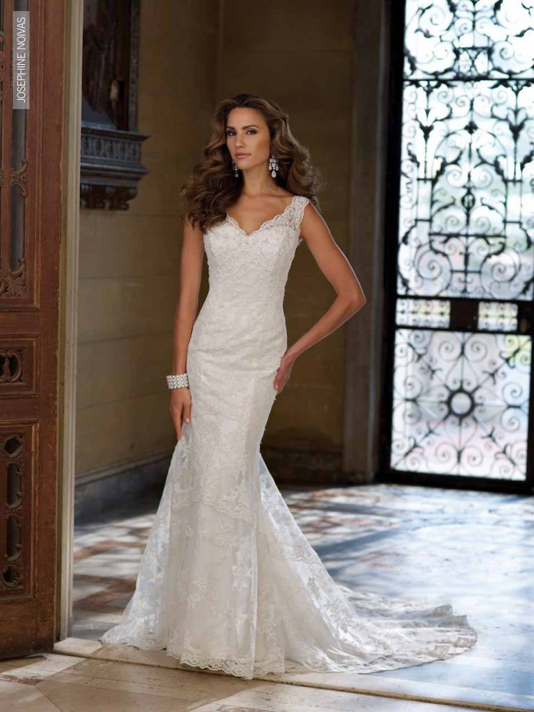 Vestido de Noiva com decote em V ,todo em renda rebordada em pedrarias e cristais, corte sereia e leve cauda.